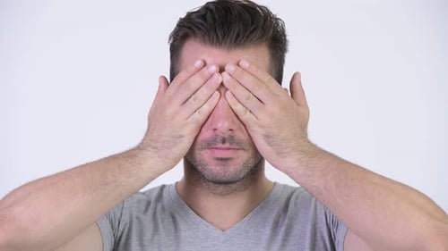 Man Covers Eyes With Hands in Close Up
