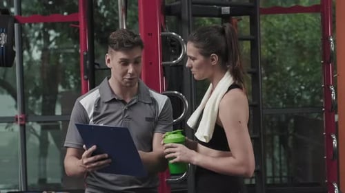 Woman Discussing Workout Program with Gym Coach