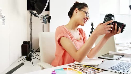 Smiling Woman Reviews Photos on Camera in Studio