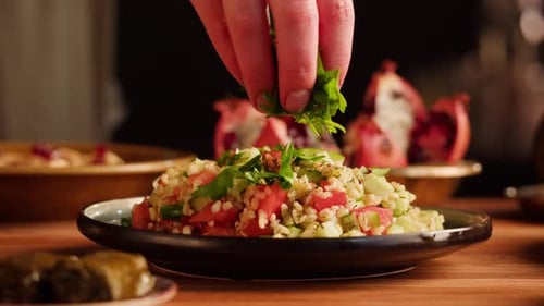 Salad Being Garnished with Herbs on Plate