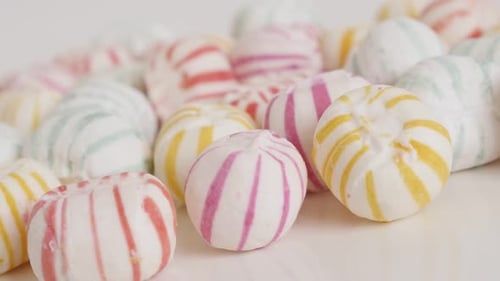 Sugar candies on white background 4K panning video