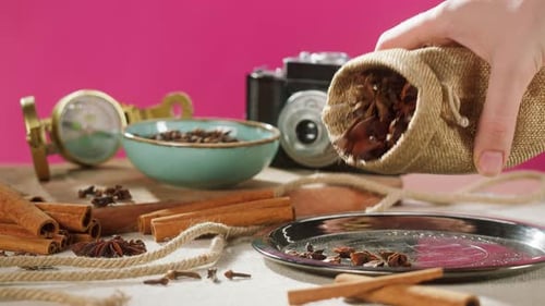 Hand pouring Star Anise onto Silver Tray