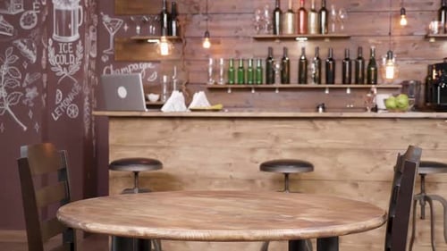 Parallax Shot of an Empty Table and Two Chairs in Front of a Bar