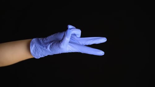Gloved Hand Forms a Peace Sign on Black