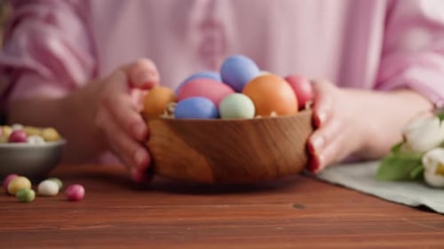 Person Places Easter Eggs on Table Close Up