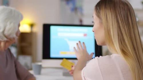 Senior Woman Learns Online Shopping with Adult Woman