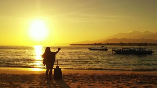 Beautiful smiling lady on holiday spending quality time at the beach on paradise white sand and blue