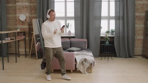 Young Adult Dancing and Listening to Music at Home