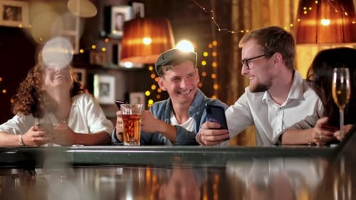 Friends Enjoying Drinks and Phones at the Bar
