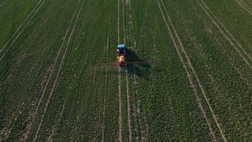 Tractor Spray Fertilizer on Agricultural Field Aerial View