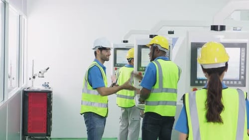 Group of interracial worker people wearing protective safety equipment helmet and work in factory.