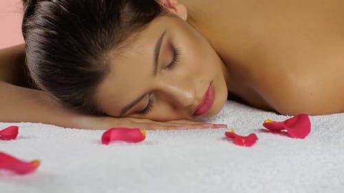 Girl Sleeps After Spa Treatments on Towels with Rose Petals