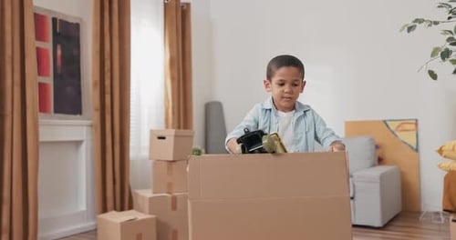 A Cute Little Boy Unpacks His Toy Box After Moving to a New House Pulls Out a Car Enjoys It Plays
