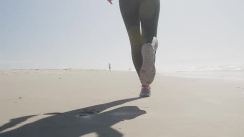 Athletic woman running on the beach