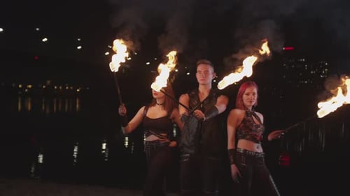 Performers Posing with Flaming Batons at Night