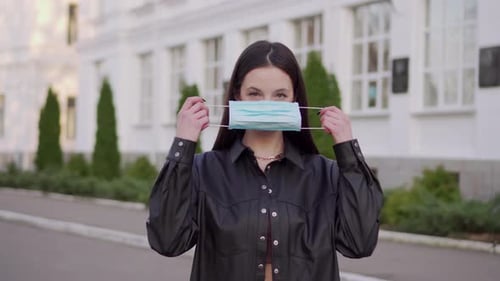 Woman Puts on Surgical Mask in City