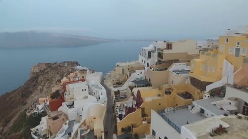 Aerial footage of Oia castle and port on Santorini Island in Greece during sunrise