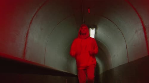 Young Guy Running through Tunnel with Red Light
