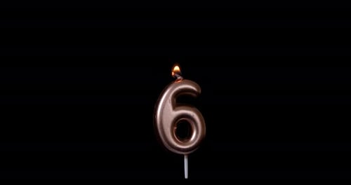 Burning Number Six Birthday Candle on Black Background