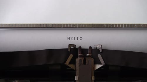 Typing word HELLO on retro typewriter. Close up.