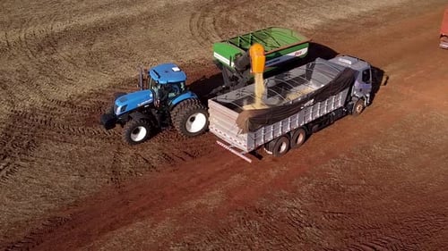Loading Grain Into Truck with Tractor on Farm