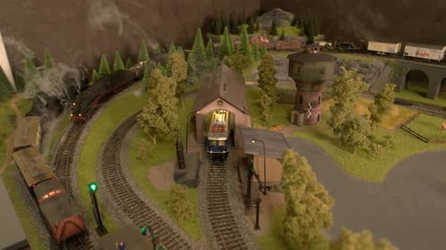 Modele trens com vapor se movendo na ferrovia.