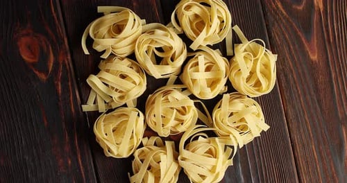 Overhead Shot of Tagliatelle Nests on Dark Wood