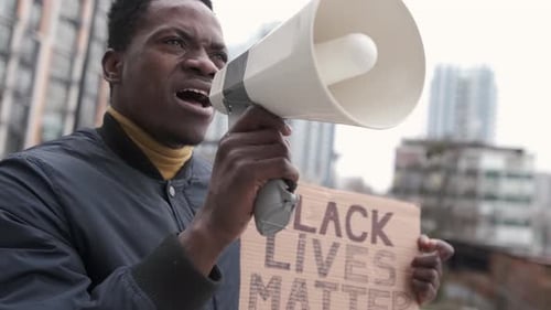 Young Adult Speaking into Megaphone at Protest