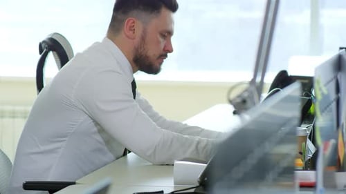 Concentrated Man Typing on Laptop Computer