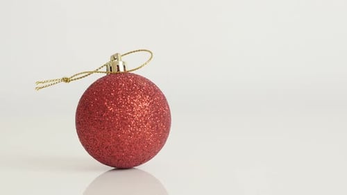 Shiny red bauble with sequins close-up 4K 2160p 30fps UltraHD tilting footage - Christmas ornament