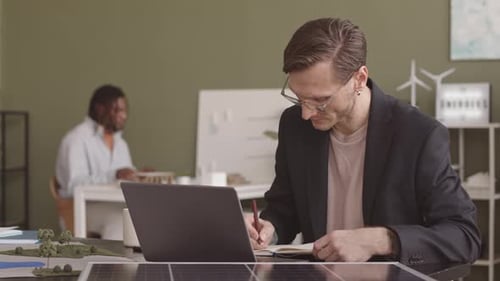Alternative Energy Engineer Working at Desk in Office