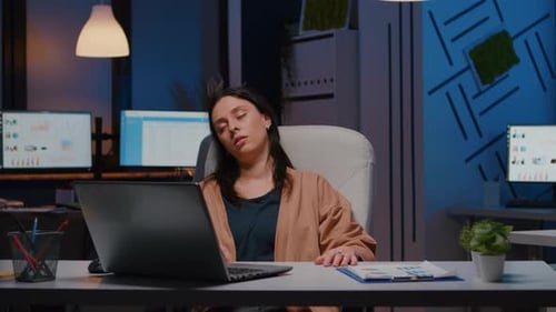 Tired Woman Awakens at Her Desk in Office