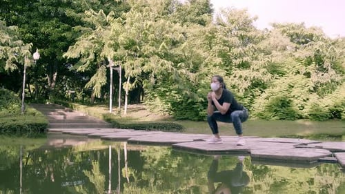 Asian woman exercise in park outdoor with new normal in COVID-19 situation