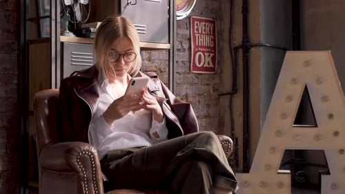 Blonde Woman Using Smartphone in Urban Apartment