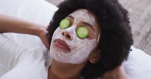 Close up of african american woman wearing face mask laying on the bed