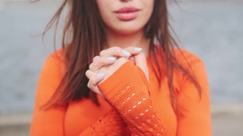 Healthy adult woman in orange sportswear doing exercises. Close-up of hands. Hand warm-up. 50 fps