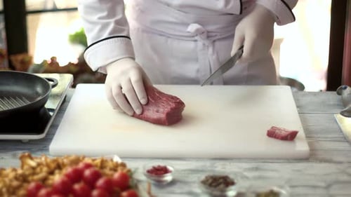 Chef Slicing Fresh Red Meat in Kitchen