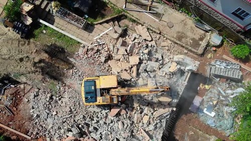 Excavator Operates with Rubble of Abandoned Cottage at Site