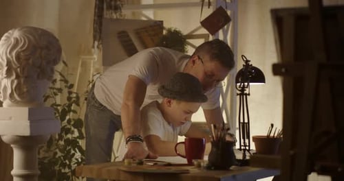 Father Helping Child Drawing at Home