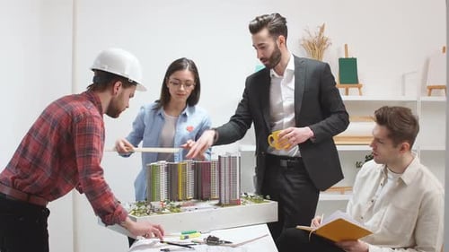 Architects Reviewing Building Model in Office