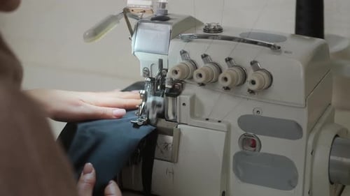 Stitching on sewing machine. Tailor sews on sewing machine. Close-up of woman's hand