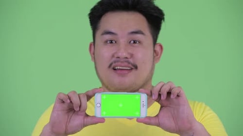 Young Adult Presenting Phone with Chroma Key Screen