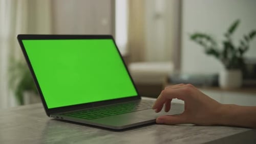 Caucasian Woman's Hand Swiping on a Laptop Touchpad with a Chroma Key Green Screen on It