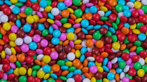 Rotating Background From Multicolored Sweets or Chocolate drageeThe Concept of Celebrating a