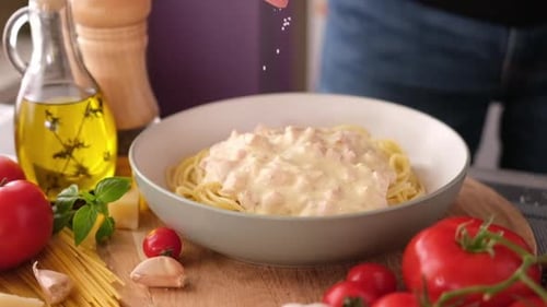 Chef Sprinkles Parmesan on Bowl of Spaghetti Carbonara