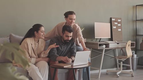 Colleagues Using Laptop while Coworking in Office