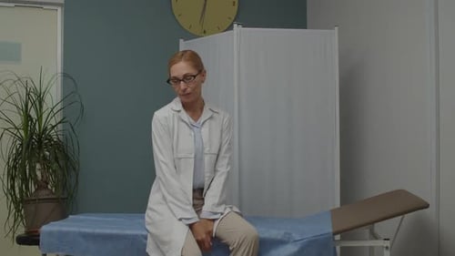 Exhausted Female Doctor Lying on Hospital Couch Indoors Tiredness