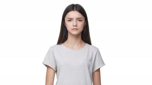 Porträt eines seriösen brünetten Schulmädchens mit langen Haaren, das eine Shh-Geste mit Zeigefinger auf den Lippen macht