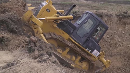 Bulldozer Digging and Moving Dirt on Construction Site