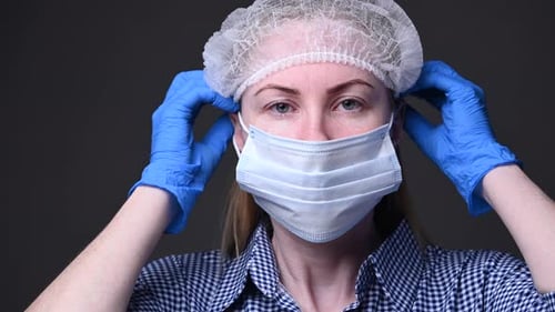 Adult Puts on Protective Surgical Mask